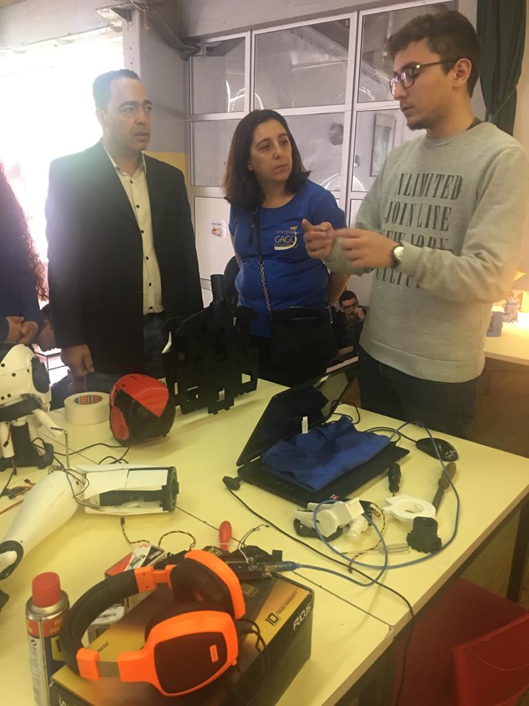 Close-up of the same open day conversation, with printed robot parts and tools spread across the table.